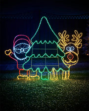 Red, warm white, ice white and green LED Santa, Rudolph and Christmas tree light in a snowy garden in front of a garden fence