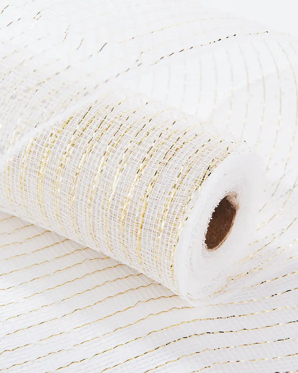 Roll of white mesh fabric with gold thread on a white table