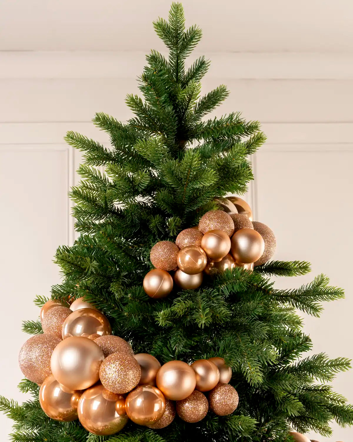Rose Gold Bauble Cluster Arch wrapped around a Christmas tree, showing clusters of rose gold baubles in different sizes and finishes