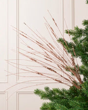 Rose Gold Glitter Wispy Spray with long, slender glitter-covered stems arranged in a fan shape on a Christmas tree
