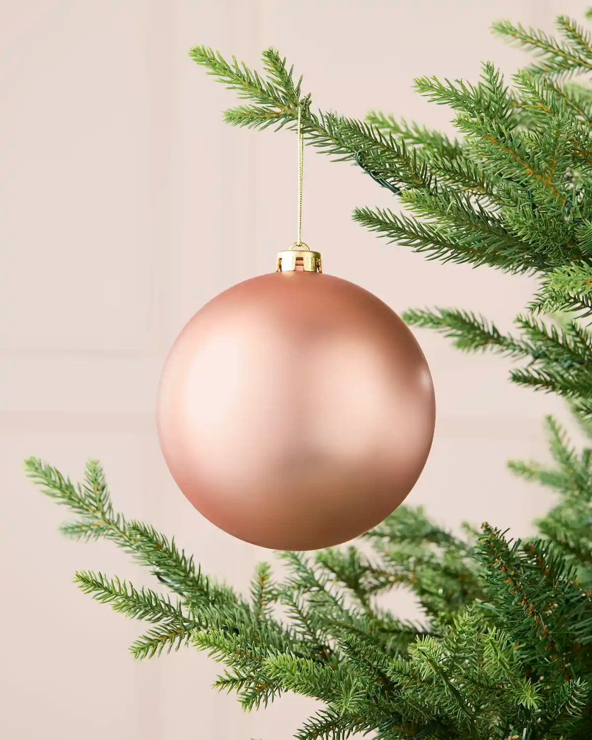 Rose gold oversized matt shatterproof bauble hanging on a Christmas tree, 15 cm