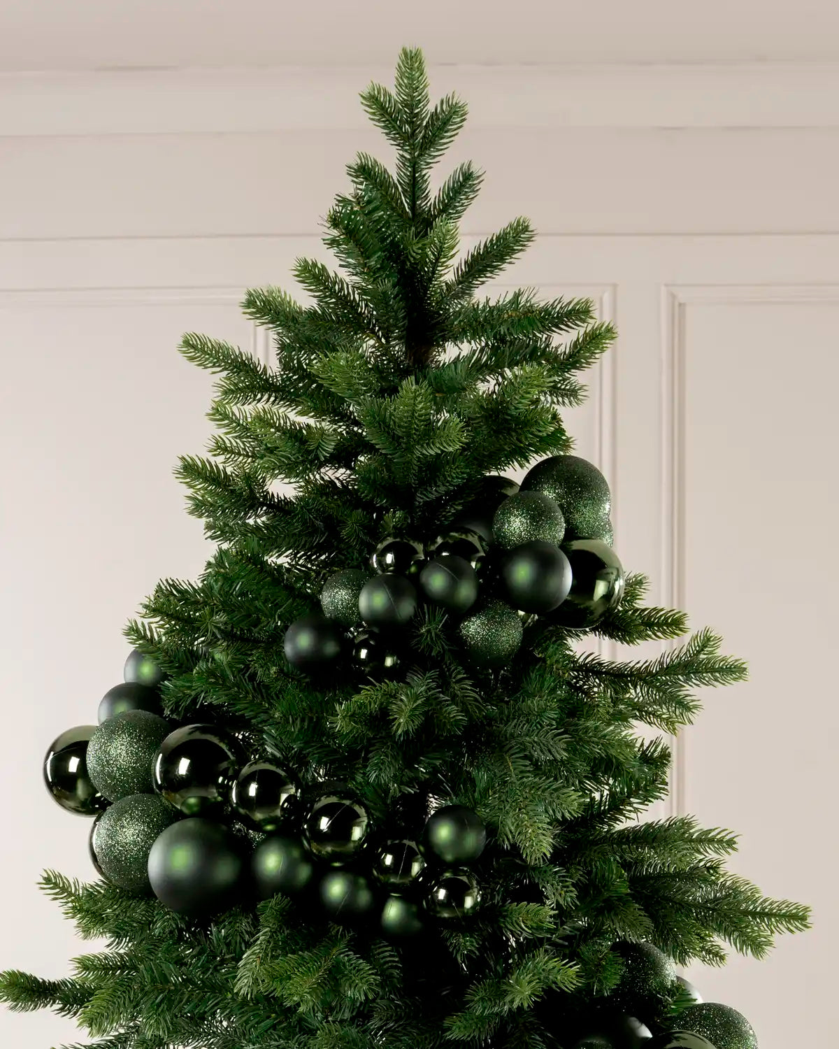 Sage Green Bauble Cluster Arch wrapped around a Christmas tree, showing clusters of sage green baubles in different sizes and finishes