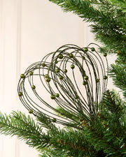 Sage Green Glitter Nest Christmas Tree Pick placed in green Christmas tree branches with a cream background
