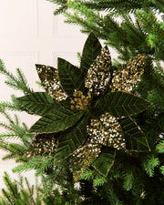 Sage Green & Gold glitter artificial poinsettia flower displayed on a Christmas tree, featuring layered pointed petals with gold glitter outlining the edges and veins and a sparkling gold center.
