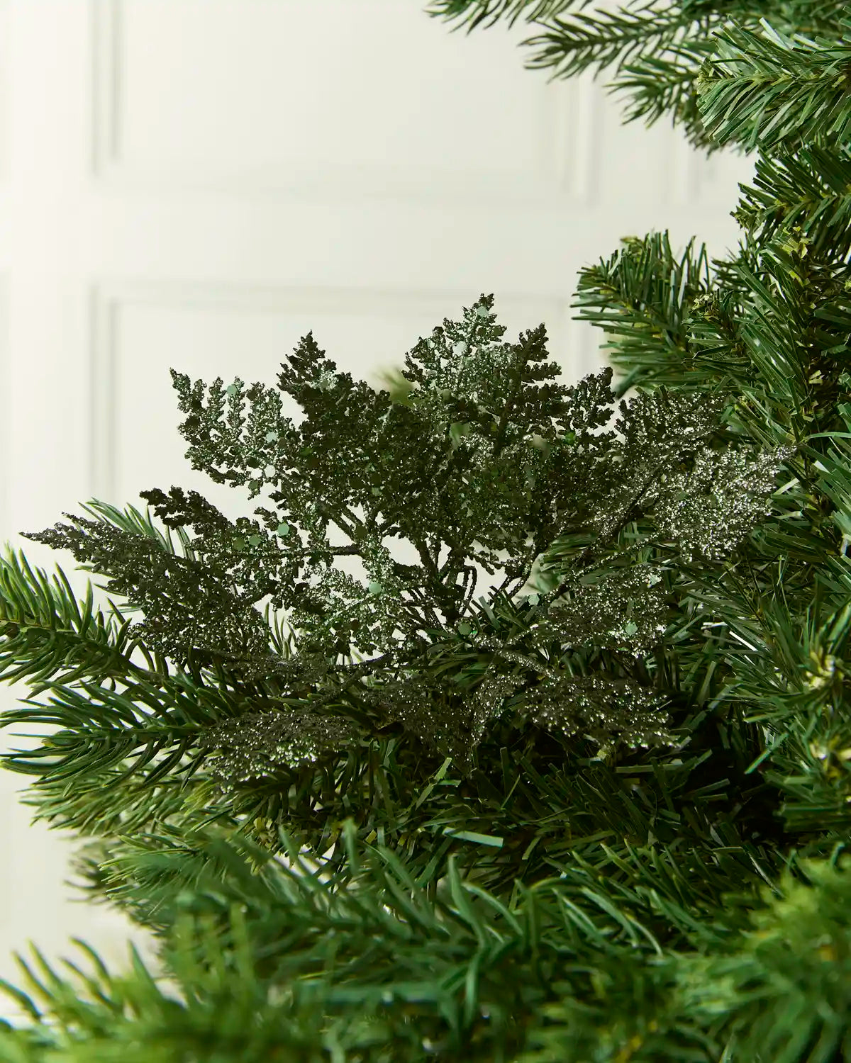 Sage green Glitter Leaf Pick placed in a Christmas tree