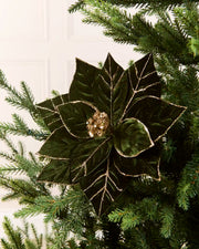 Sage green glitter artificial poinsettia flower displayed on a Christmas tree, featuring layered pointed petals with gold glitter outlining the edges