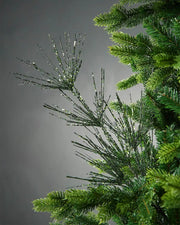 Sage green glitter firework spray on tree in front of grey background