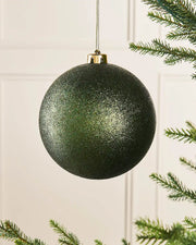 Sage green glitter oversized 15cm bauble on a Christmas tree branch