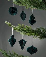 Set of 6 10cm sage green paper honeycomb tree decorations hanging on Christmas tree in front of grey wall background