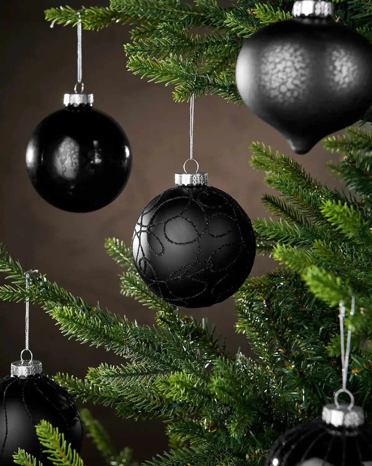 Set of 6 Black baubles on a Christmas tree with a brown background