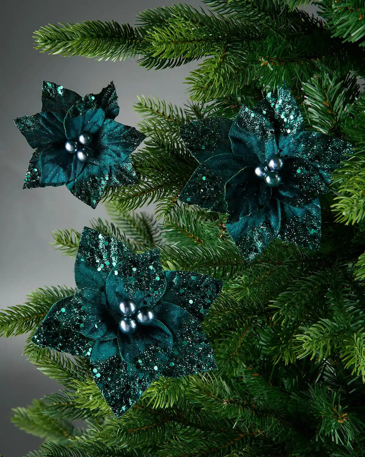 Set of three Emerald Poinsettia
glittery flower with silver clips on a Christmas tree
