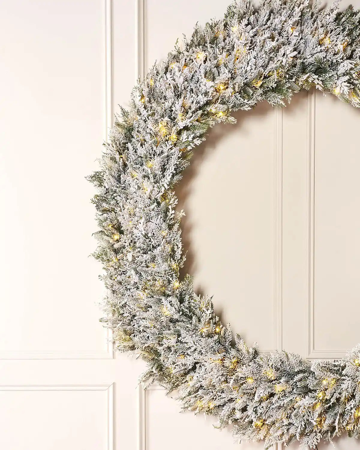 Side view of Pre-Lit Snow Flocked Natural Fir Majestic Wreath, 1.5 m on panel textured background