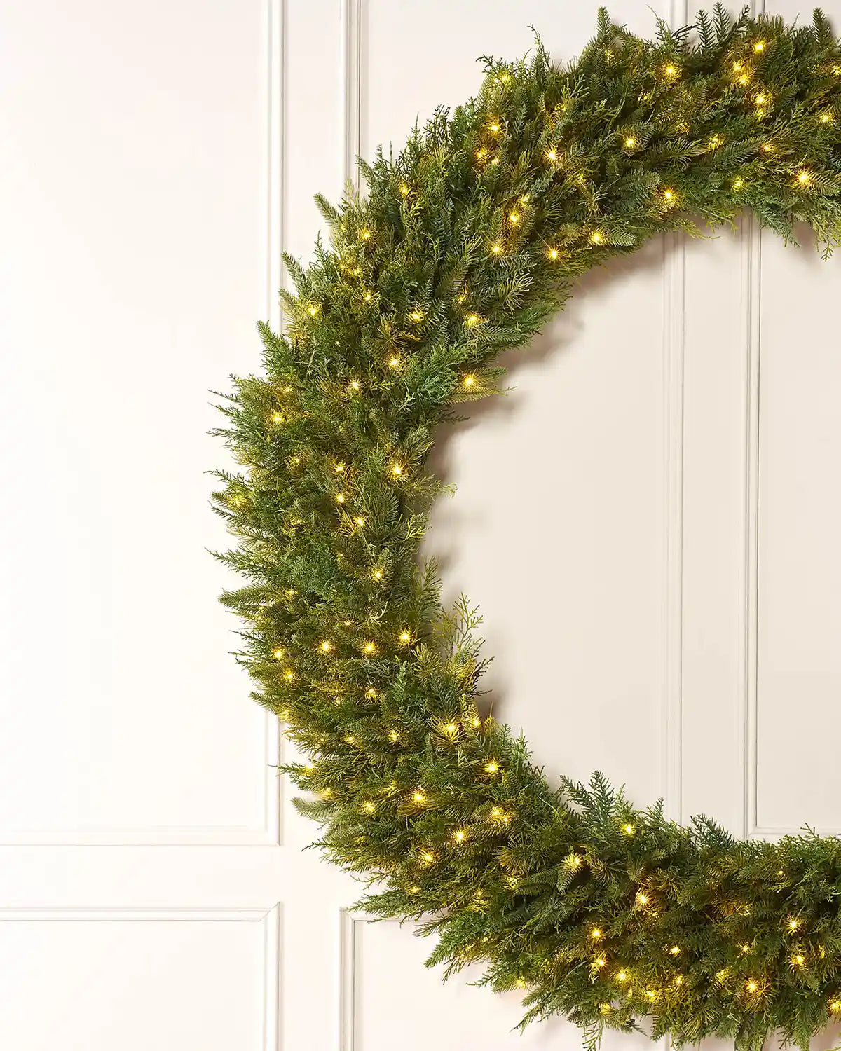 Side view of a Pre-Lit Natural Fir Majestic Wreath, 1.5 m on a panel texture background