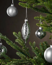 Silver Christmas baubles hanging on a tree with a dark background