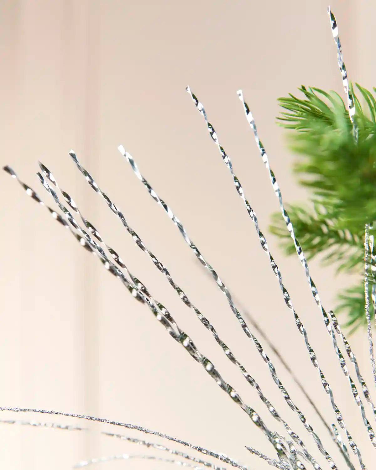Silver Glitter Fountain Christmas Tree Spray with long, slender twisted strands extending upward and outward from the center of a Christmas tree
