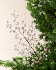 Silver berry pick, tree topper with white faux pearls and silver crystal accents, shown nestled in green pine tree branches.