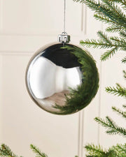 Silver gloss 15cm oversized bauble on a Christmas tree branch 