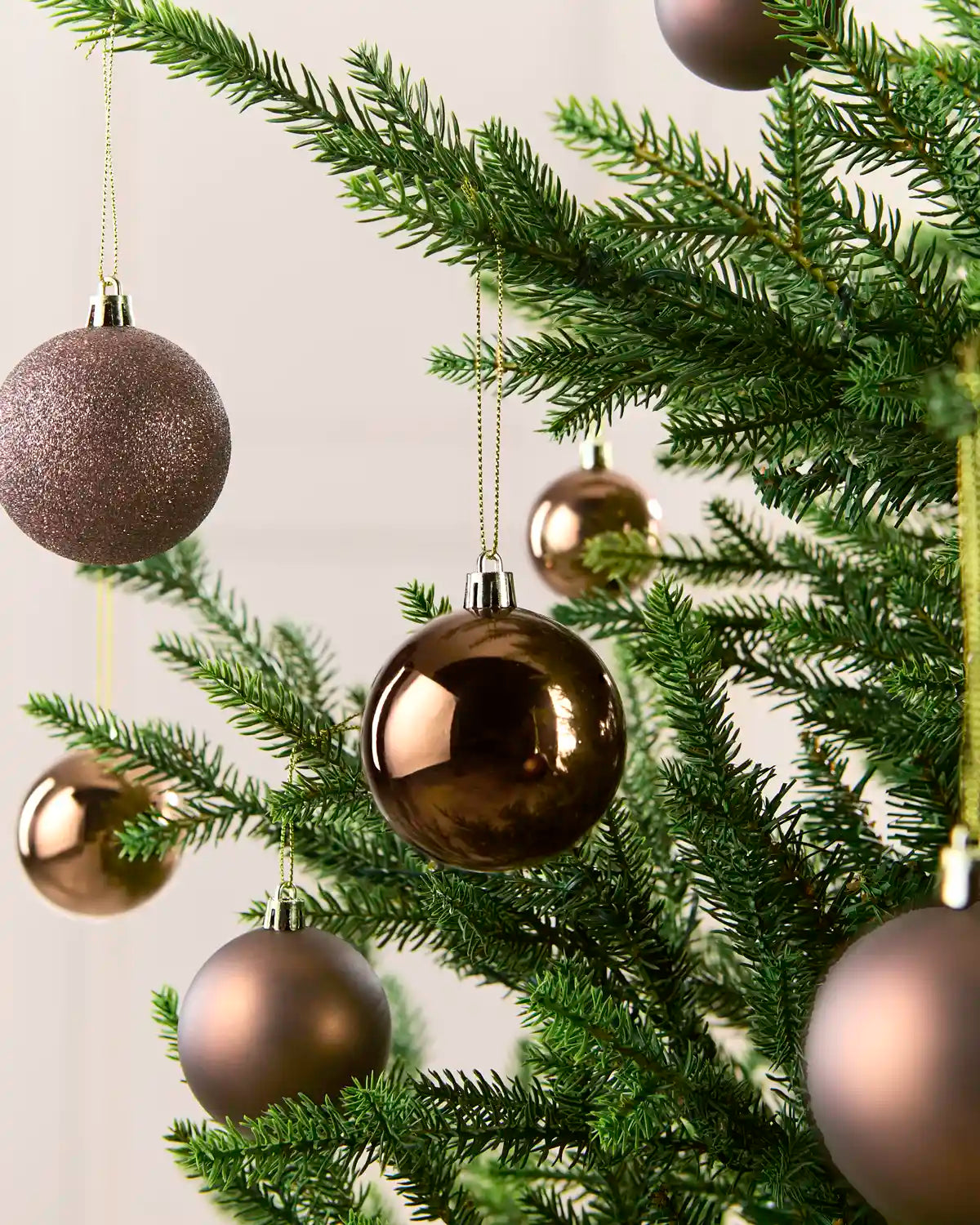 Small Mocha coloured Baubles on a Christmas tree against a cream background