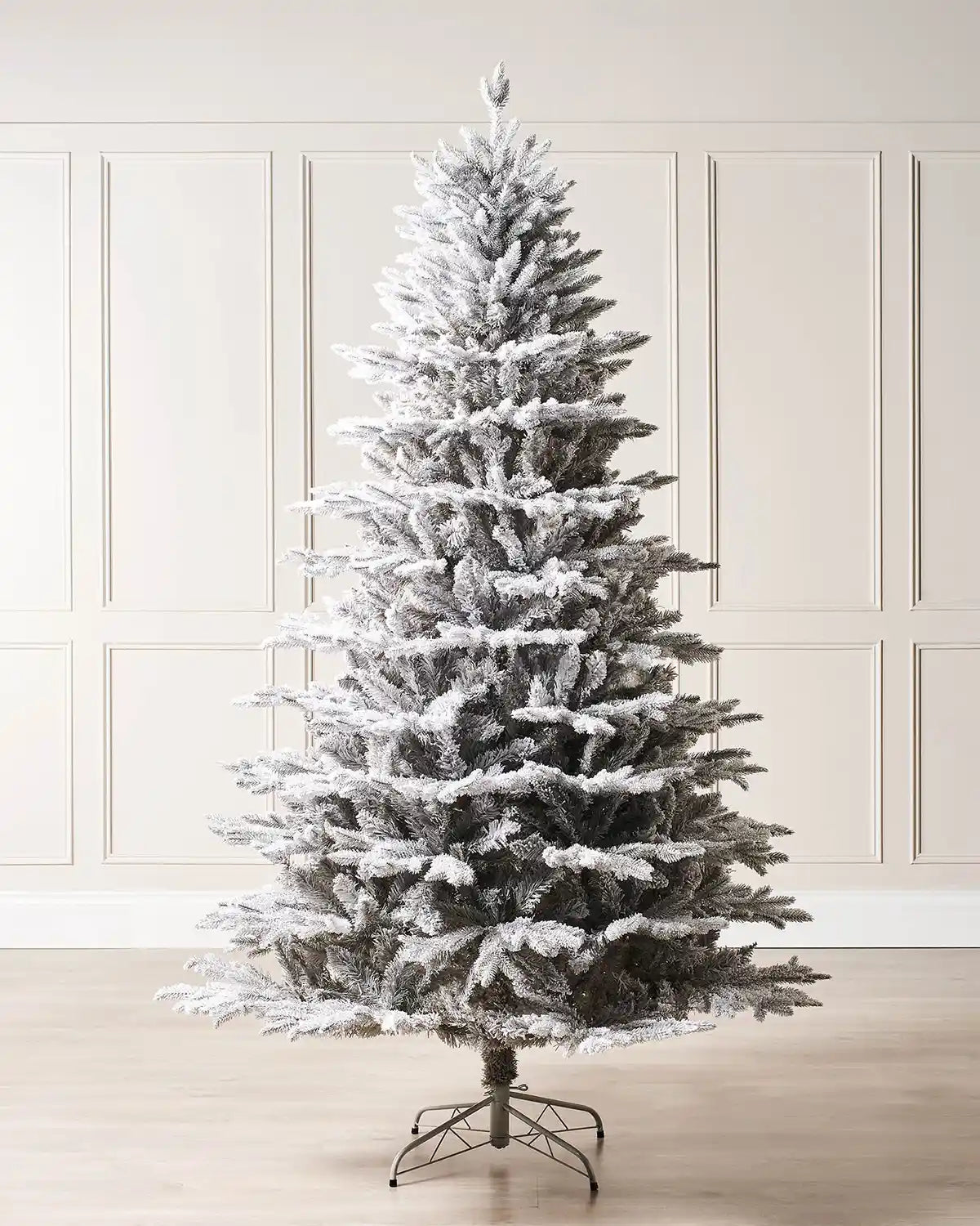 Snow flocked Christmas tree on a cream panel wall