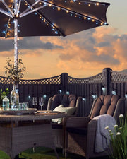 Sunset setting in a garden with chairs, table and warm white and ice white string lights