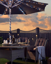 Sunset sky in Garden with chairs, table, umbrella with Warm white and ice white lights blanket some candles 