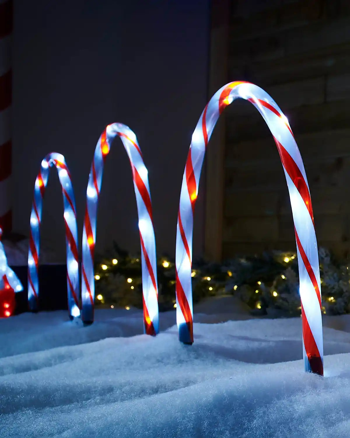 Three Candy Cane Arch Pathway Stake Lights in a snowy garden 