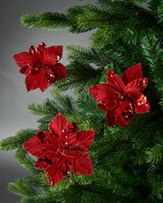 Three red sequin Poinsettia flowers on Green Christmas tree 