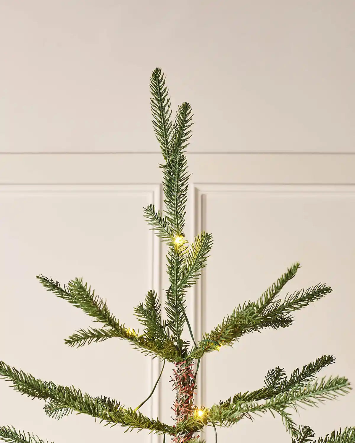 Top of a of Pre-Lit Nordmann Fir Christmas Tree, 7 ft PVC and PE tips with single lit bulbs 