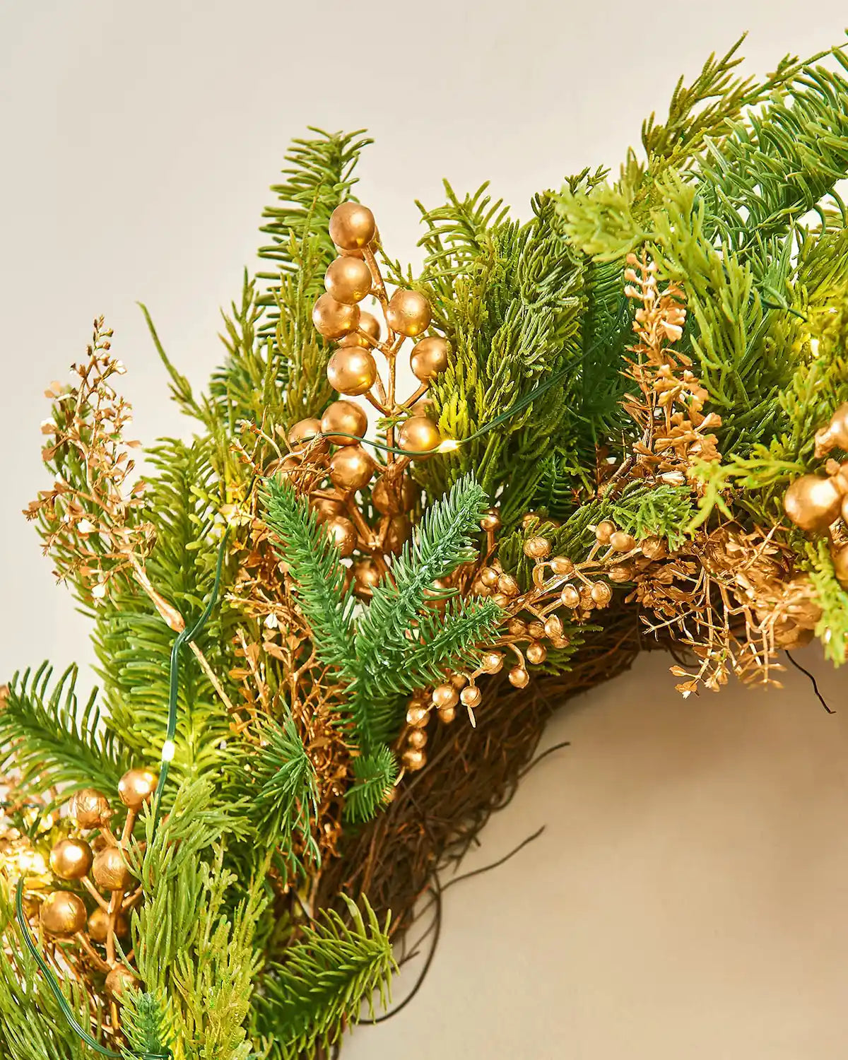 Top view Decorative Gold Berry wreath with greenery and small lights on a white background