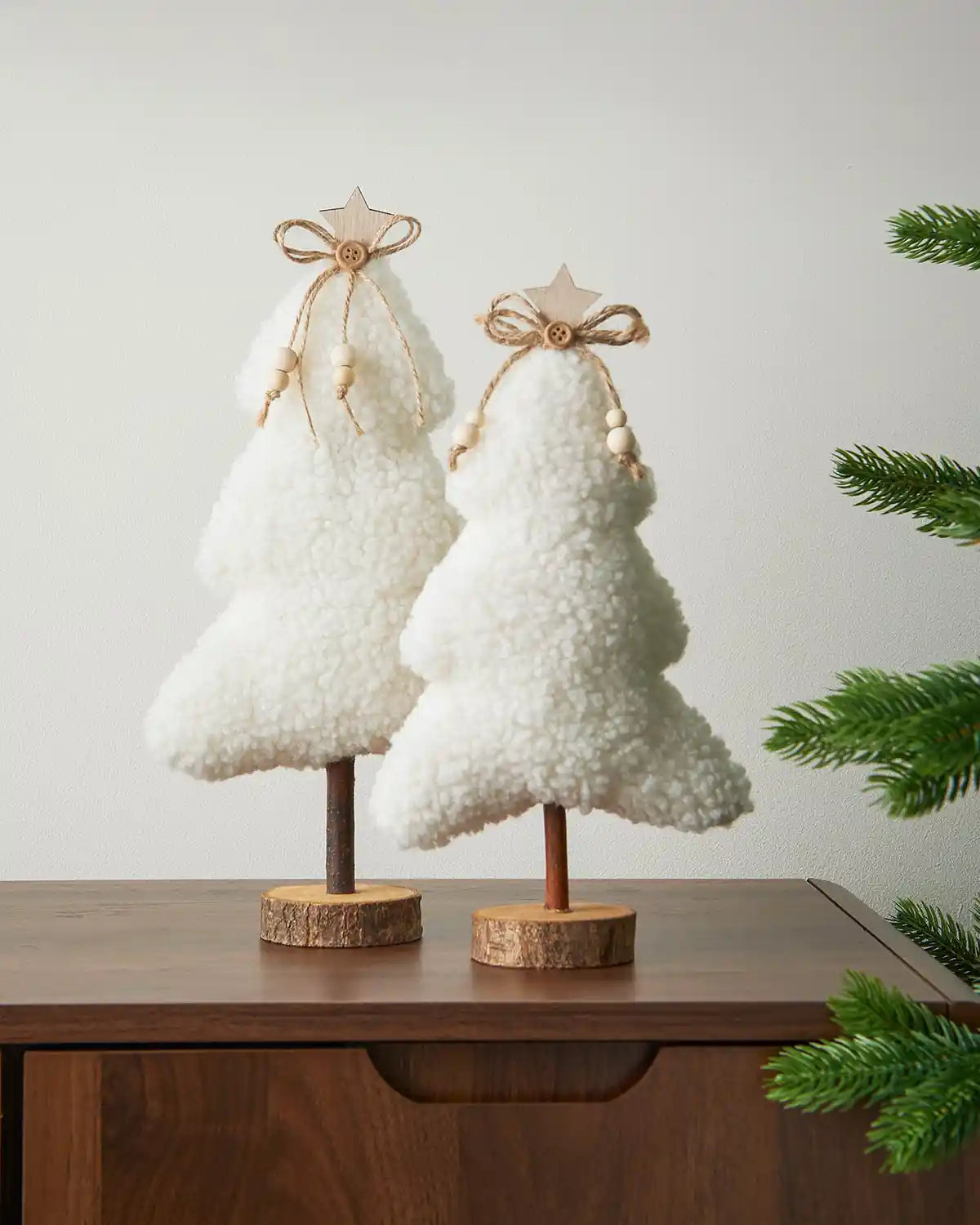 Two sherpa mini trees on a wooden table against a White background