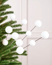 Velvet Bauble Picks in white arranged on green Christmas tree branches
