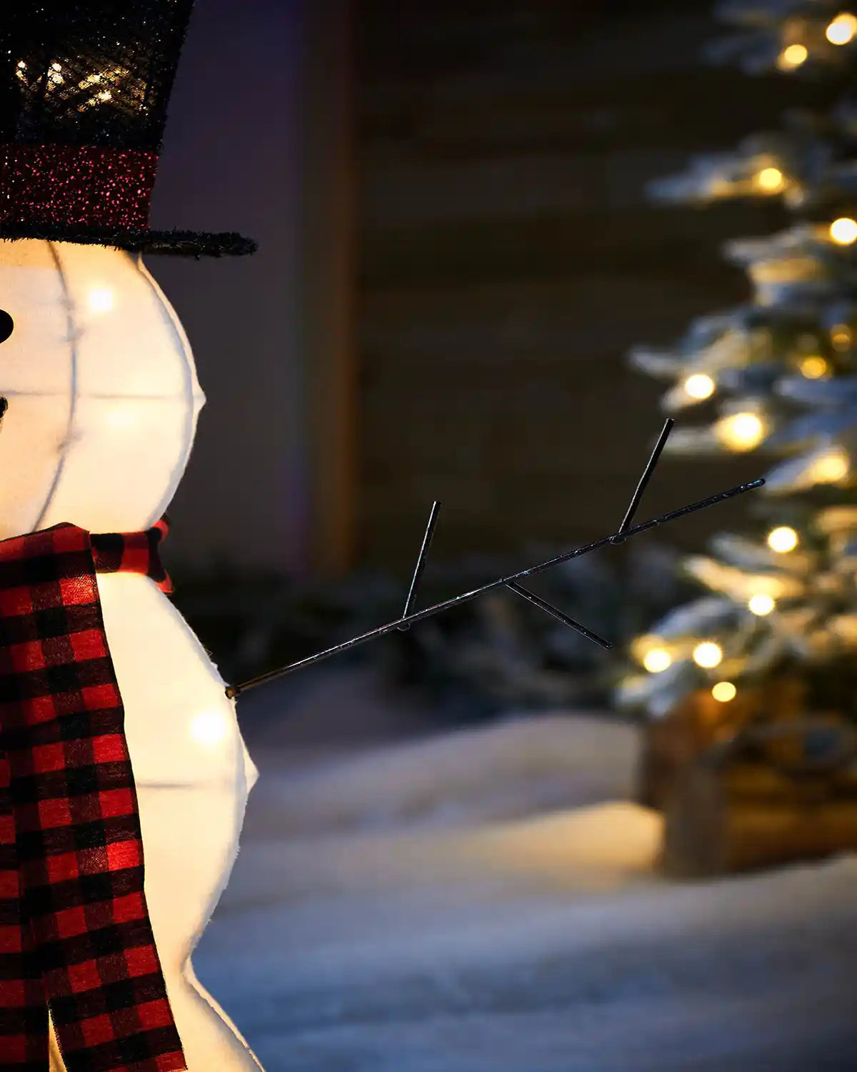 Close up of Snowman's stick arm with red and black scarf part of Pre-Lit 3D Snowman, Silhouette, 95 cm in a snowy garden