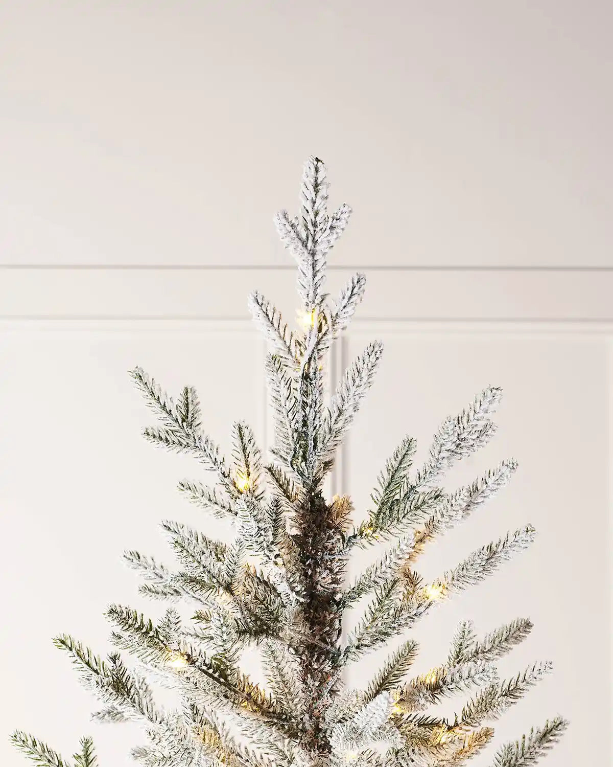 Close up of the top of a 8ft Snow Flocked Douglas Fir's PVC and PE tips  Christmas Tree with lights 
