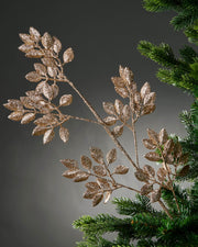 Decorative glitter gold leaf branch on a grey background