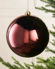 Gloss oversized burgundy bauble on a Christmas tree branch