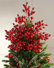 Decorative Christmas tree with red berries tree topper on a plain background