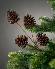 Decorative branch with pine cones on a Christmas tree branch with a grey background