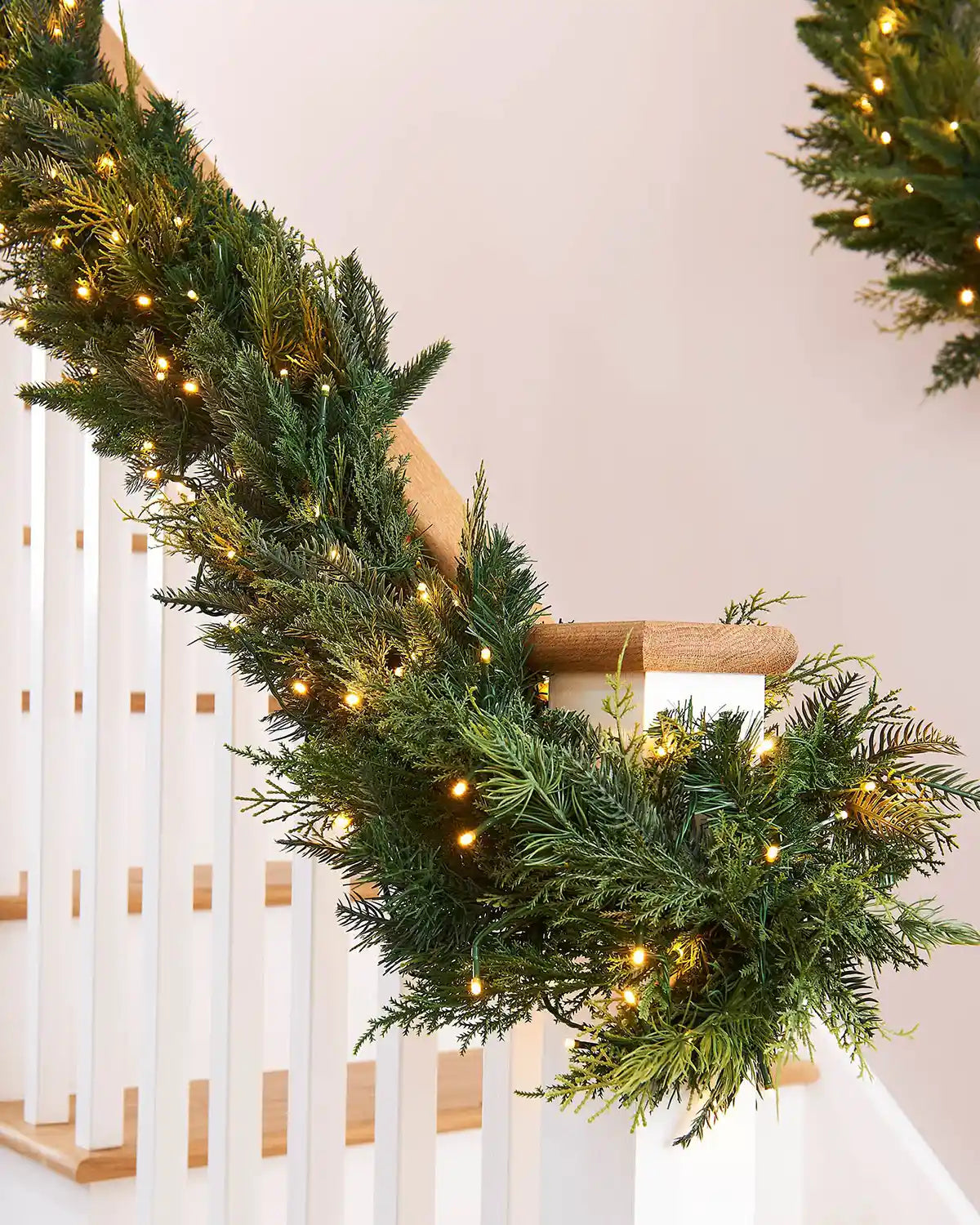 Decorative Christmas garland with warm white  lights on a staircase banister