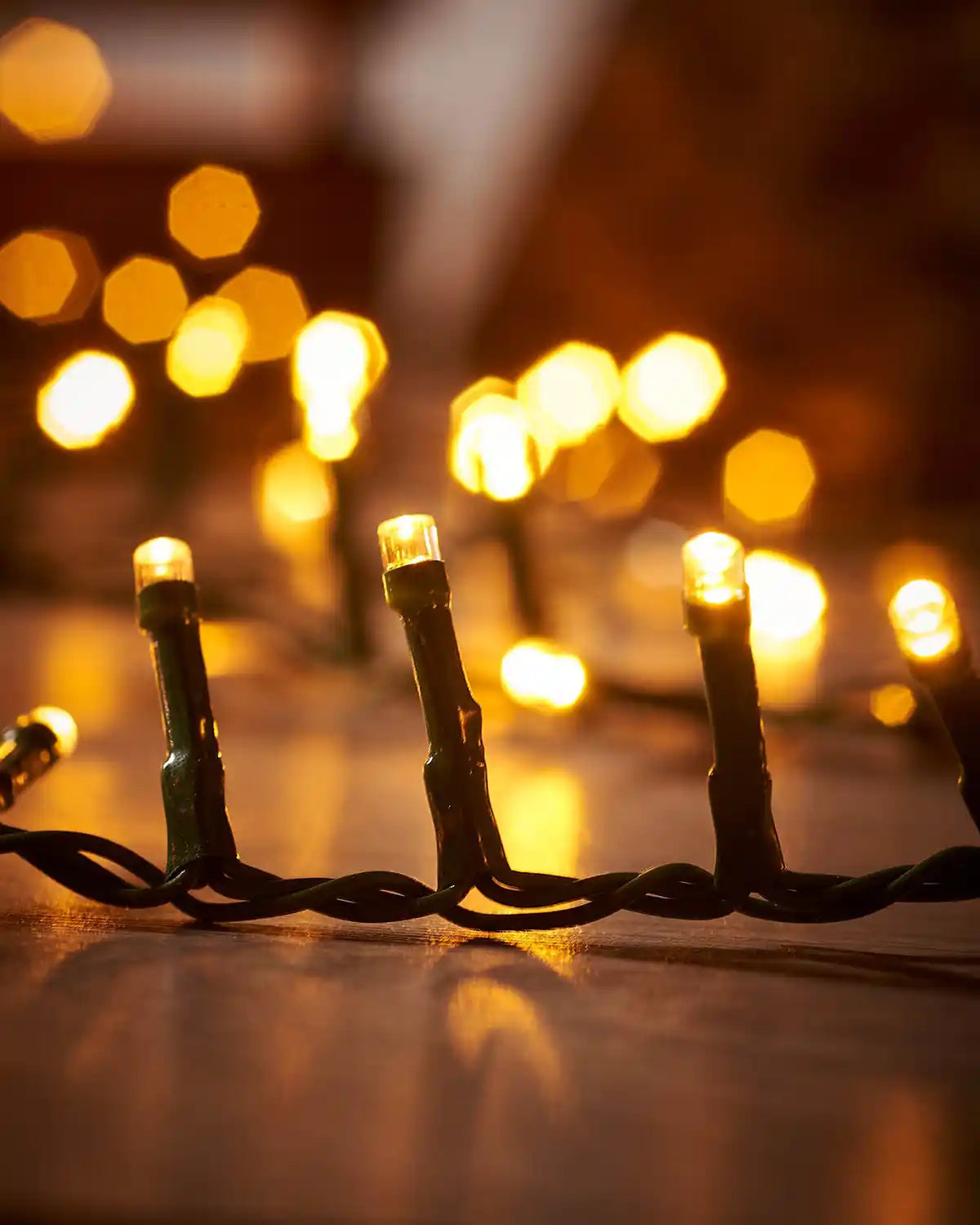 String of cluster Christmas lights with a blurred warm festive background
