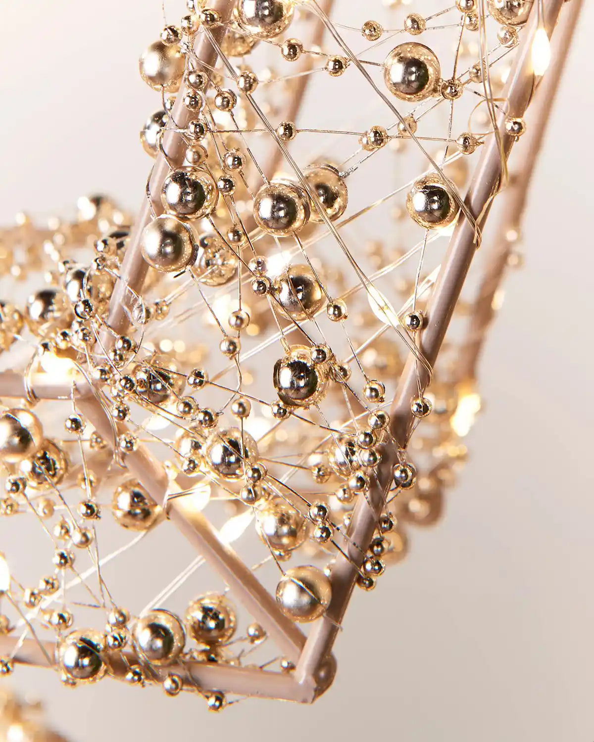Close-up of a decorative light fixture with gold spherical elements on a neutral background