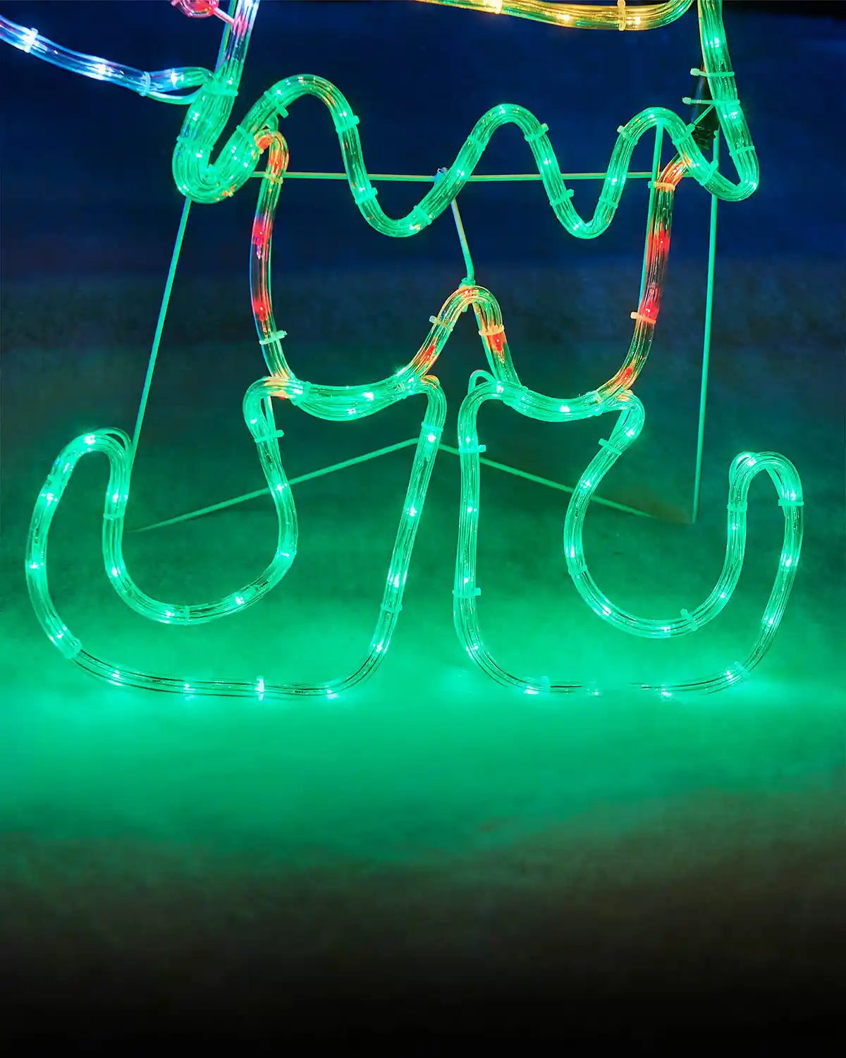 Close up of Green LED boots on a light up elf on snowy grass