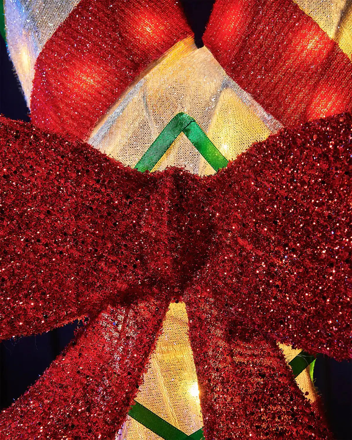 Close-up of a red glittery bow with a blurred background