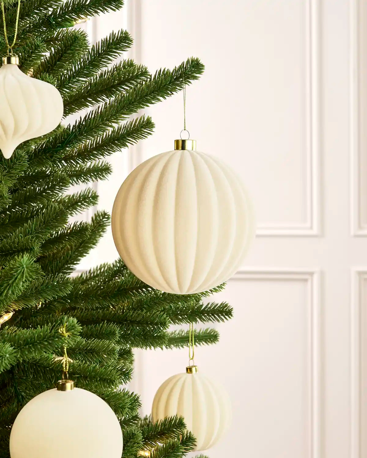 Oversized 15 cm latte velvet Ribbed bauble styled among matching decorations on a Christmas tree.
