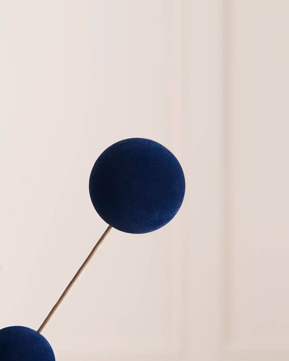 A close-up of a single velvet bauble pick against a light background 