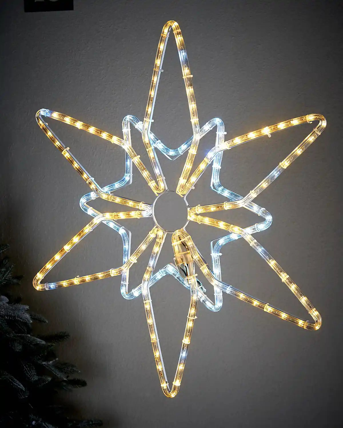 Warm white and ice white LED Northern star on light coloured garden wall