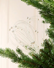 White Glitter Nest Christmas Tree Pick placed in green Christmas tree branches with a cream background
