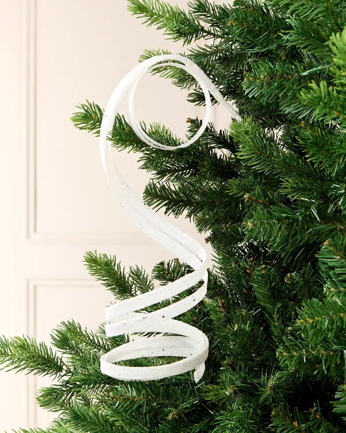 White Glitter Spiral Swirl Pick hanging from Christmas tree branch with cream background

