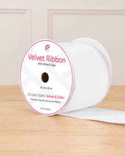 White Velvet Ribbon with wired edge on a wooden surface