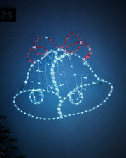White and Red Light up Christmas bell silhouette on a light coloured wall outside