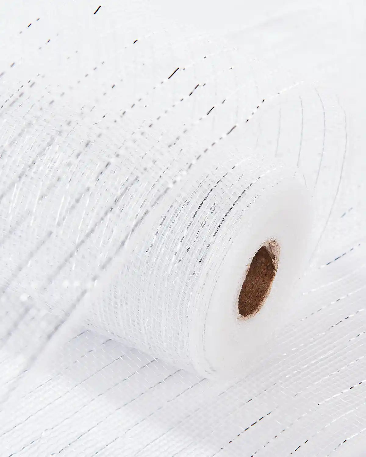 White and silver mesh ribbon fabric on a white table 